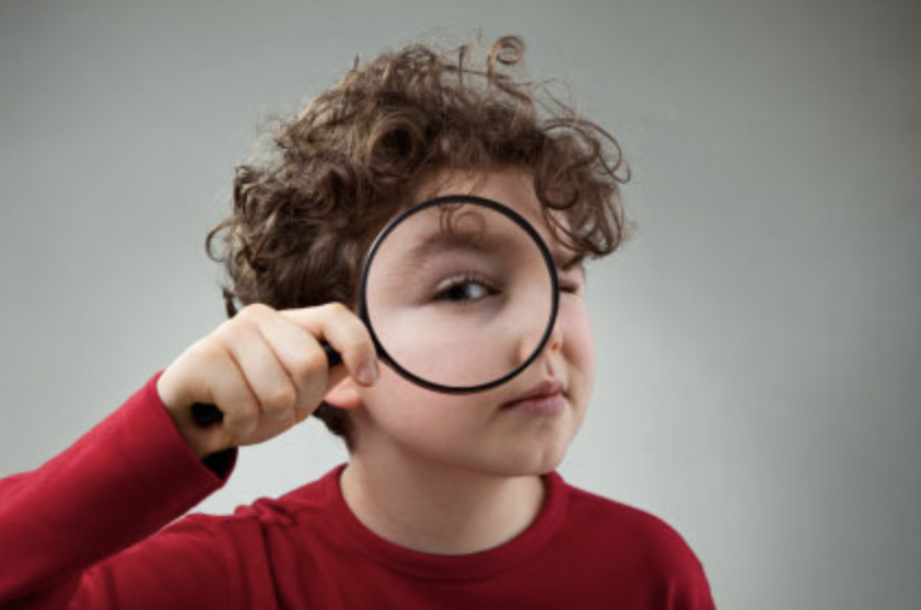 enfant avec une loupe dans sa main droite